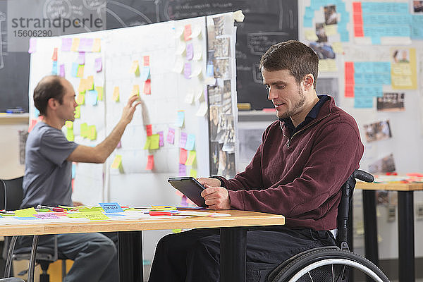 Ingenieurstudent mit Tablet während der Projektinitiierung  ein Mann mit Rückenmarksverletzung und ein anderer mit Asperger