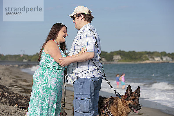 Ein blindes Paar vergnügt sich am Strand mit seinem Diensthund