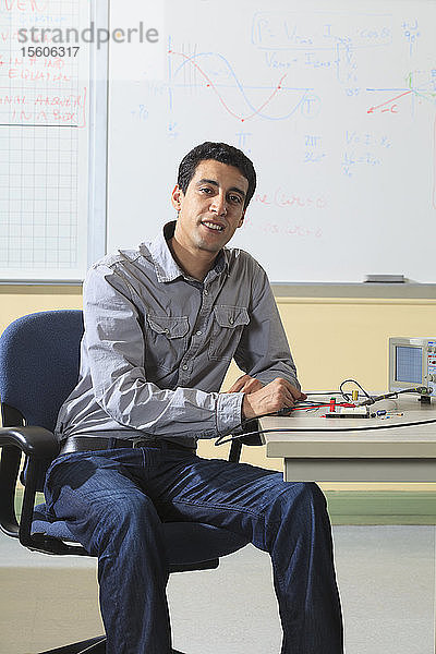 Ingenieurstudent im Klassenzimmer mit Oszilloskop und elektronischem Prototyping-Breadboard