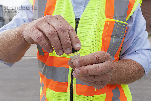 Ingenieur mit einer Wasserprobe aus einem Straßenhydranten