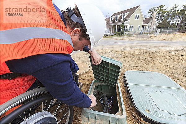 Bauingenieur mit Querschnittslähmung inspiziert Stromkasten