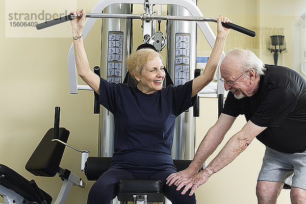 Ein älteres Paar trainiert im Fitnessstudio.