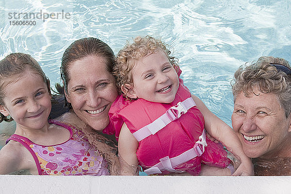 Zwei Mädchen mit ihrer Mutter und Großmutter in einem Schwimmbad