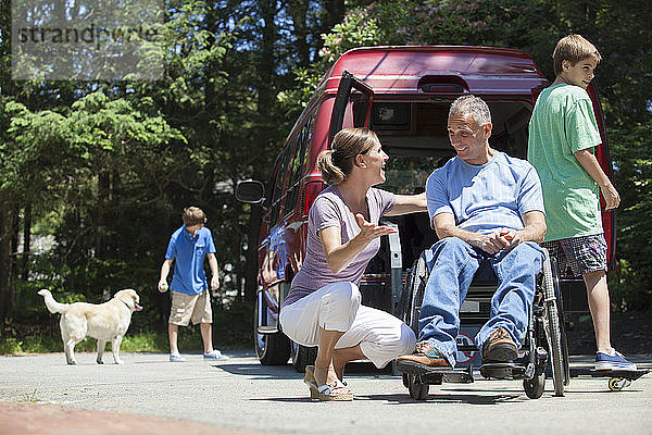 Mann mit Rückenmarksverletzung im Rollstuhl genießt seine Familie