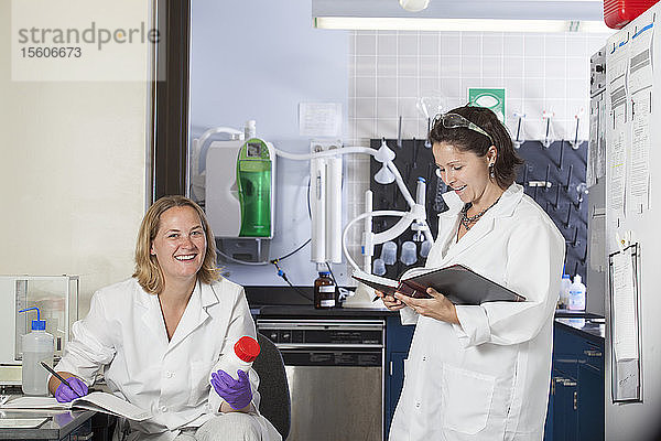 Zwei Laboranten  die in einem Labor chemische Analysedaten aufzeichnen
