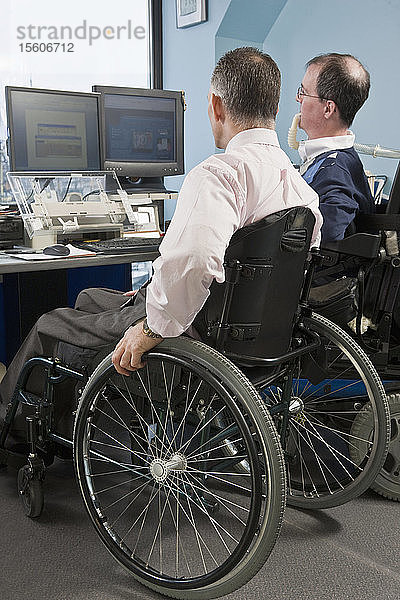 Zwei Geschäftsleute im Rollstuhl arbeiten in einem Büro