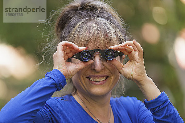 Frau mit Sehbehinderung benutzt Spezialbrille  um im Park zu sehen