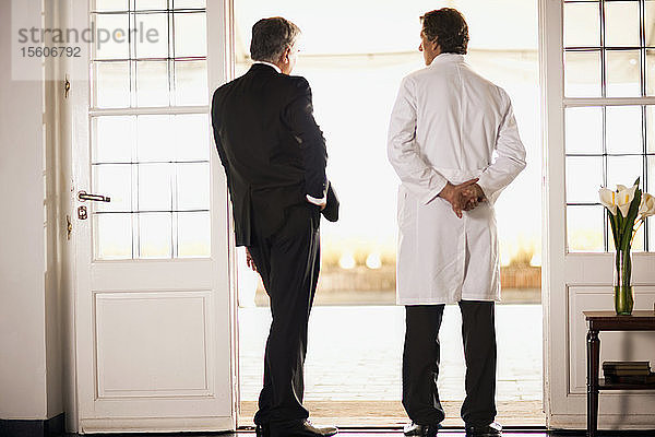 Rückansicht von zwei männlichen Ärzten im Gespräch