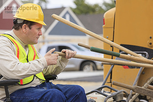 Bauleiter mit Querschnittslähmung zählt Arbeitsgeräte auf der Baustelle