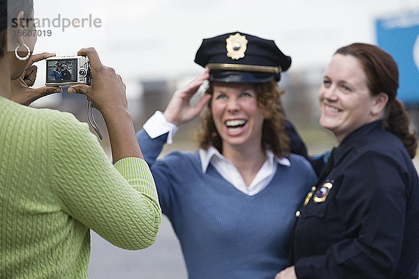 Frau  die ein Foto ihres Freundes mit einer Polizistin anklickt.