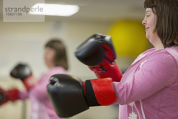 Mädchen mit Down-Syndrom trainiert mit Boxhandschuhen