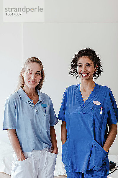 Porträt einer selbstbewussten Krankenschwester und Ärztin  die im Krankenhaus an einer weißen Wand steht