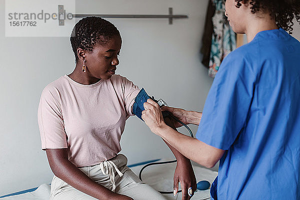Krankenschwester prüft den Blutdruck einer Patientin in der Klinik