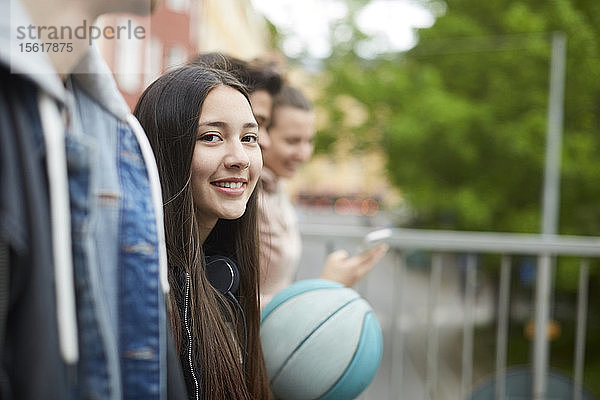 Porträt eines lächelnden Teenagers  der mit Freunden spazieren geht