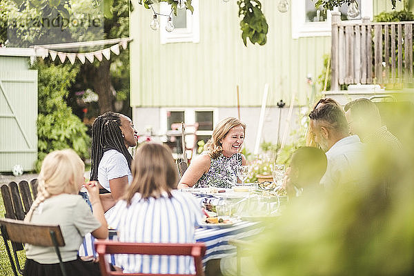 Glückliche Freunde und Familie beim gemeinsamen Essen auf der Gartenparty