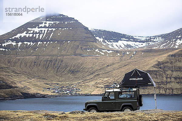Seitenansicht eines einzelnen 4x4-Autos mit Zelt  geparkt vor Bergen  Färöer Inseln  Dänemark