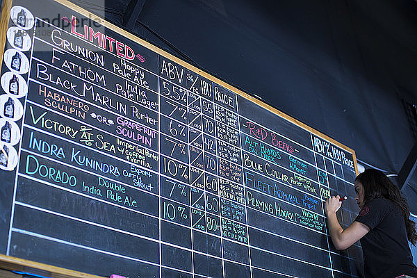 Eine Frau aktualisiert die Liste der Biere im Ballast Point Tasting Room in Miramar  Kalifornien.