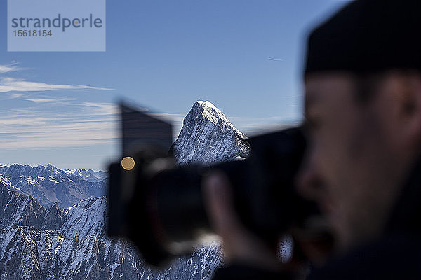 Fotograf beim Fotografieren im Mont-Blanc-Gebirge mit Berggipfel im Hintergrund  Chamonix-Mont-Blanc  Haute-Savoie  Frankreich