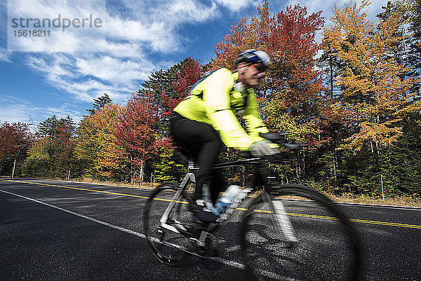 Ein Radfahrer fährt auf dem farbenfrohen Kancamagus Highway in New Hampshire.