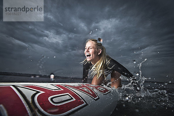 Eine Paddelboarderin lacht während einer Session auf dem Wasser in San Diego  CA.