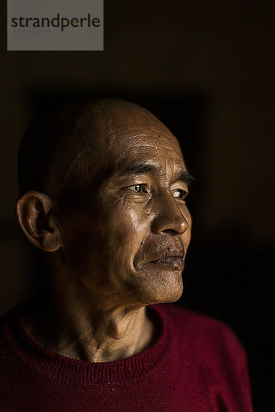 Dunkles Porträt eines reifen Mönchs  der wegschaut  Myanmar  Shan  Myanmar