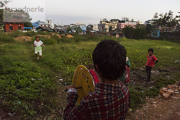 Vier Kinder spielen mit einer Spule in einem ländlichen Dorf  Myanmar  Shan  Myanmar
