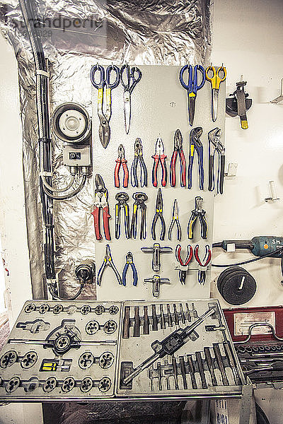 Mechanikerwerkzeuge hängen an einer Wand in der Werkstatt eines Containerschiffs.
