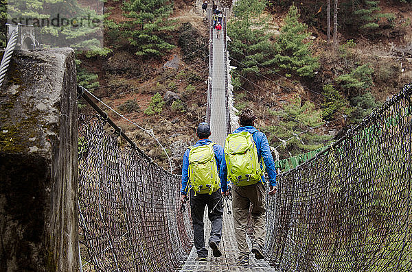 Männer beim Überqueren einer Seilbrücke auf dem Weg zum Mount Everest im Sagarmatha-Nationalpark