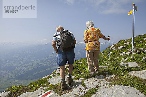 Ein nicht identifiziertes Paar wandert in der Toggenburger Region der Schweizer Alpen weit über dem Wallener See.