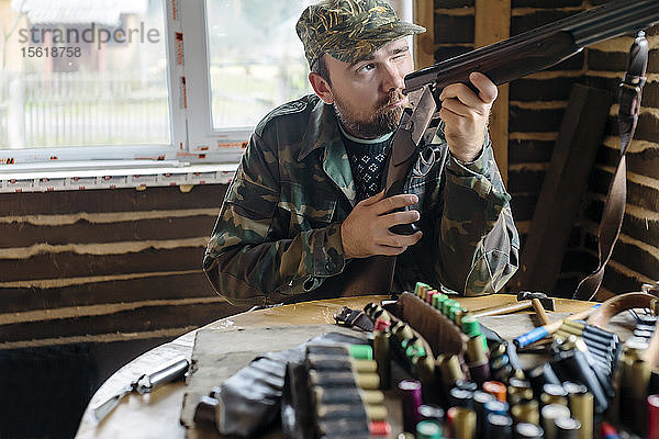 Vorderansicht eines Mannes  der bei den Vorbereitungen für einen Jagdausflug das Visier seiner Flinte überprüft  Tichwin  Sankt Petersburg  Russland