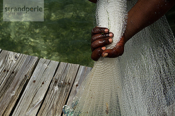 Nahaufnahme der Hand eines Mannes  der ein Fischernetz hält  Isla Marisol  Belize