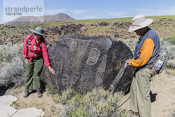 Zwei Fremdenführer stehen neben einem mit Petroglyphen übersäten Felsen  Ridgecrest  Kalifornien  USA