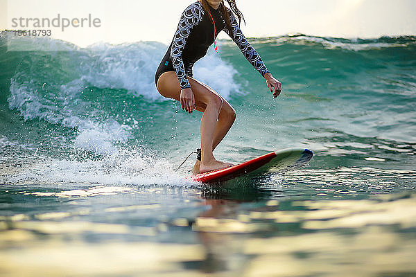 Frau surft auf einer Welle