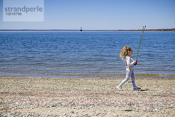 Mädchen mit mechanischem Greifer bei der Strandsäuberung am Earth Day  Portsmouth  Rhode Island  USA