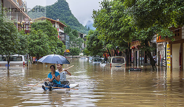 Paar schwimmt auf einem Floß während der Überschwemmungen in Yangshuo