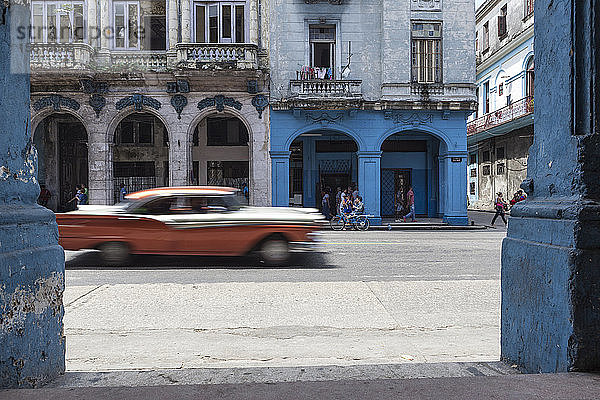 Langzeitbelichtung eines alten orangefarbenen amerikanischen Autos aus den 50er Jahren in der Straße von la havana vieja (Alt-Havanna)  Kuba