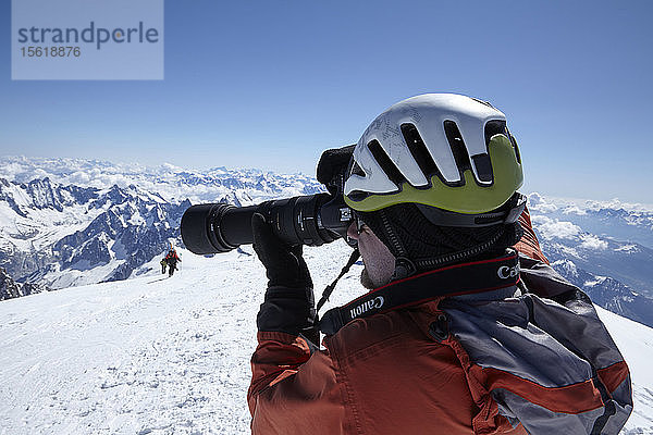 Hochschnitt eines Mannes  der schneebedeckte Berge fotografiert  Schweiz