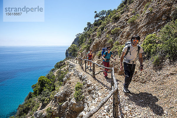 Ein Junge und zwei Mädchen wandern auf dem ersten Abschnitt des Selvaggio Blu  einer 6-tägigen Wanderung  die wegen des Wassermangels  einiger Kletter- und Abseilpassagen und der oft schwierigen Wegfindung als der härteste Wanderweg in Europa gilt. Sardinien  Italien.
