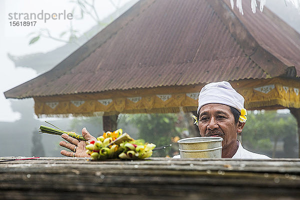 Ein hochheiliger Mann nimmt in einem indonesischen Tempel auf Bali  Indonesien  eine Segnung vor