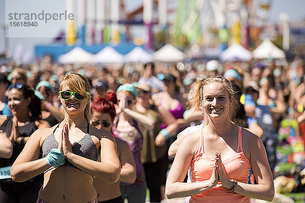 Menschen  die während des Outdoor-Yoga-Festivals am Santa Monica Pier in Santa Monica  Kalifornien  USA  die Hände zum Herzen führen