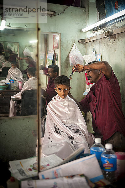 Ein Junge lässt sich die Haare schneiden  Kottayam  Kerala  Indien.