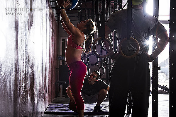 Eine Sportlerin trainiert mit einem Medizinball  während ihr Trainer in einem Fitnessstudio in San Diego  Kalifornien  zusieht.