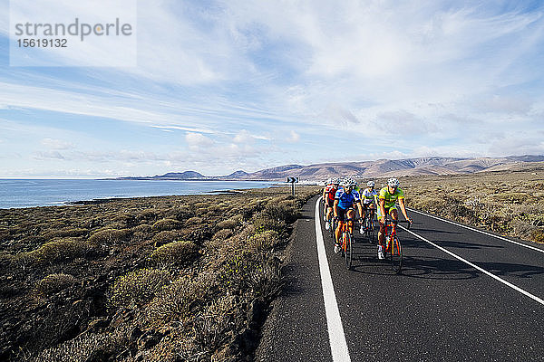 Gruppe von Rennradfahrern auf der Straße nahe der Küste  Lanzarote  Kanarische Inseln  Spanien