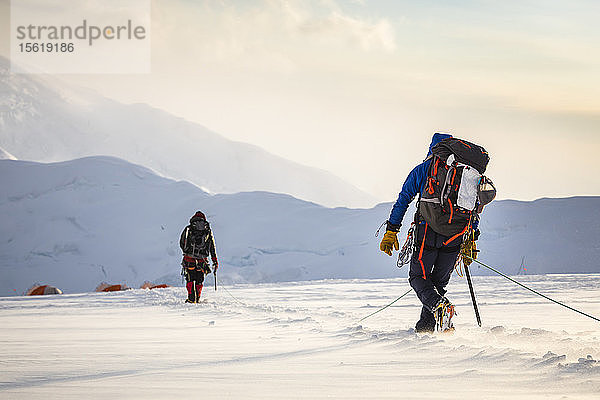 Rückansicht von zwei Bergsteigern  die auf einem Gletscher zum Lager zurückkehren  Denali National Park  Alaska  USA