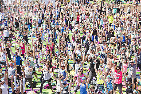 Menschen  die während des Yoga-Festivals am Santa Monica Pier in Santa Monica  Kalifornien  USA  den Krieger 1 ausführen
