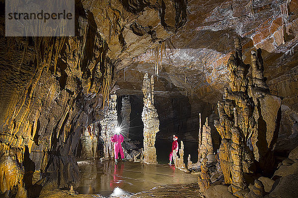 Zwei Männer erkunden die Höhle Krizna Jama. Karstgebiet  Slowenien. Diese Höhle ist eine weltbekannte Wasserkarsthöhle  deren Besonderheiten zahlreiche unterirdische Seen  verschiedene Tierarten und der Aufenthaltsort eines Höhlenbären sind.