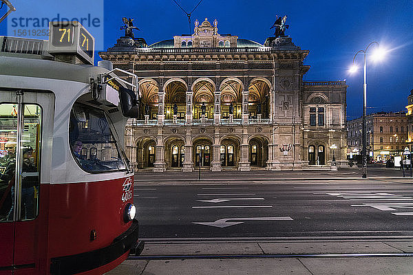 Beleuchtete Wiener Staatsoper bei Nacht mit Straßenbahn im Vordergrund  Wien  Österreich