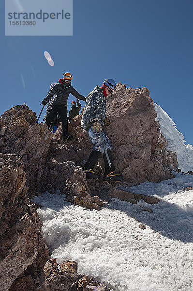 Jungen im Alter von 13 bis 17 Jahren von der Venturing Crew 191 aus Glendora  Kalifornien  setzen ein Jahr Training in die Praxis um  als sie versuchen  den Gipfel des Mount Shasta über die Avalanche Gulch-Route im Shasta Trinity National Forest in Nordkalifornien zu erreichen. Der Mount Shasta ist ein massiver  vergletscherter Vulkan und mit 14.179 Fuß der zweithöchste Gipfel in der Cascade Range und der fünfthöchste in Kalifornien; er ist mit keinem anderen Gipfel verbunden und erhebt sich abrupt 10.000 Fuß über das umliegende Gelände. Die Pfadfinder der Venturing Crew 191 (Venturing Crews sind ein Zweig der Pfadfinder  der sich auf abenteuerliche Aktivitäten konzentriert) hatten sich ein Jahr lang auf ihre Besteigung des Mount Shasta vorbereitet. Dies war ihre erste Erfahrung mit dem Klettern in steilem Schnee  und sie wurden bei ihrem Aufstieg von Führern der SWS Mountain Guides unterstützt. Josh Kolbach (vorne)  Betreuerin Sandy Howlett und Dillon Travis von Venturing Crew 191 beginnen den Abstieg vom Gipfel des Mount Shasta  14.179 Fuß  über ein Felsband  Shasta Trinity National Forest  Kalifornien
