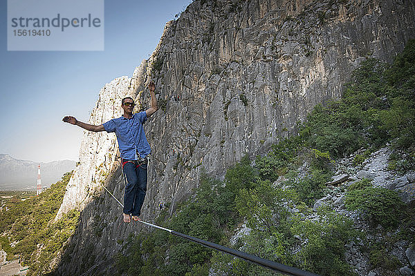 Abenteuerlustiger Mann beim Slacklinen zwischen zwei Felswänden in El Portero Chico  Monterrey  Mexiko