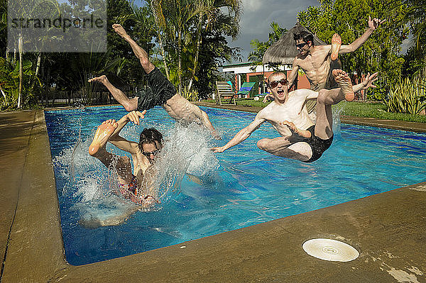 Gruppe von Männern  die im Schwimmbad springen